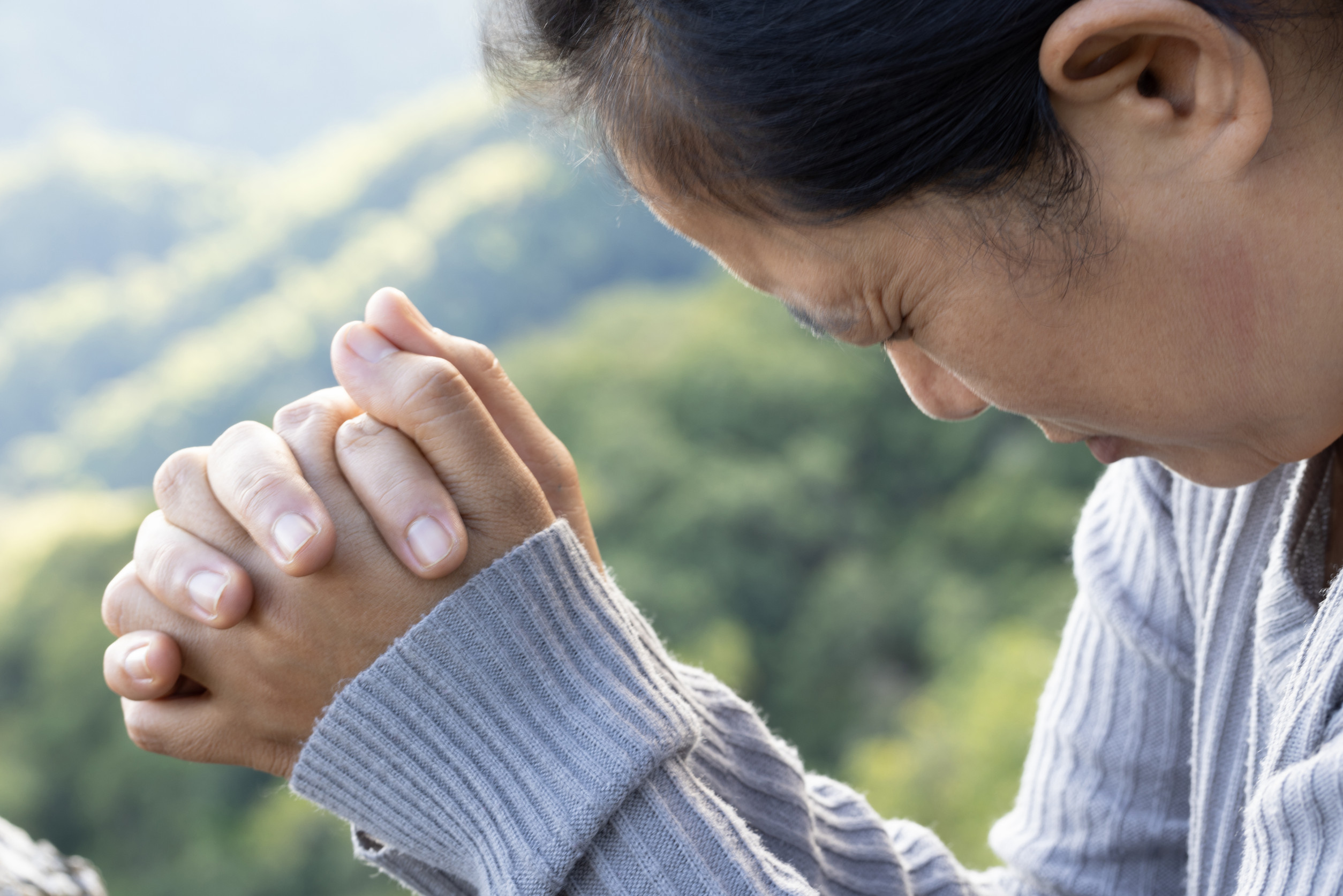 Woman praying and worshiping God on the mountain for a good life.