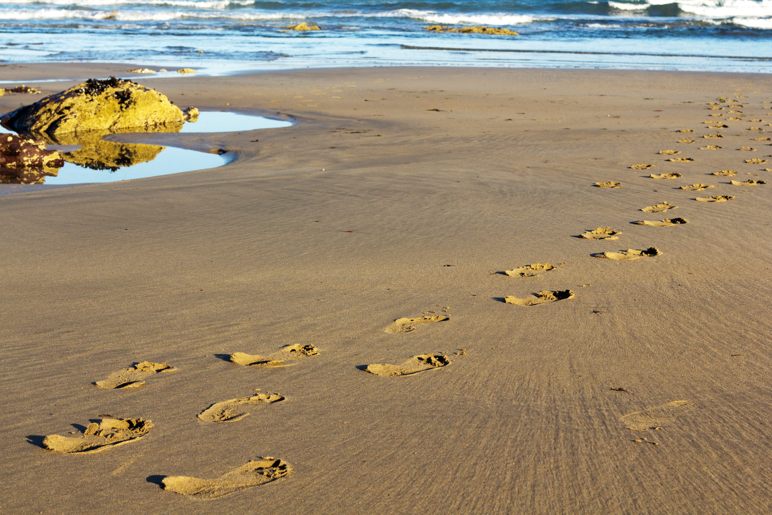 Footprints in the sand on Polzeath beach, Cornwall